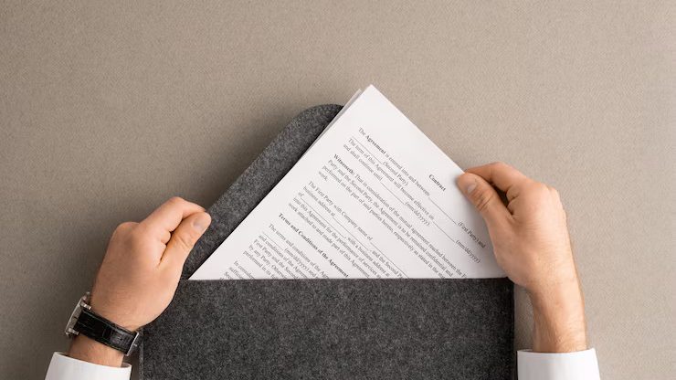 overview-hands-contemporary-manager-broker-taking-financial-contract-out-large-grey-envelope-before-reading-signing-it_274679-14458